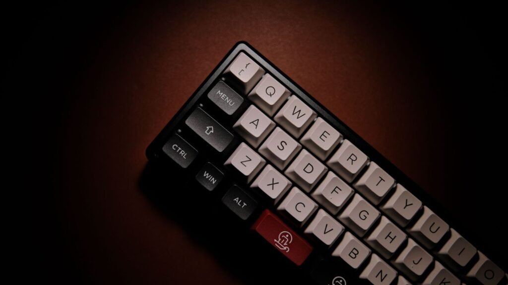 Close-up of a black compact mechanical keyboard with white letter keycaps and dark modifier keys labeled Menu, Ctrl, Win and Alt