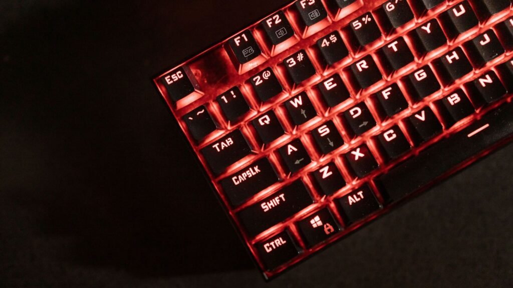 Black mechanical keyboard with red backlighting shining through the keycap legends