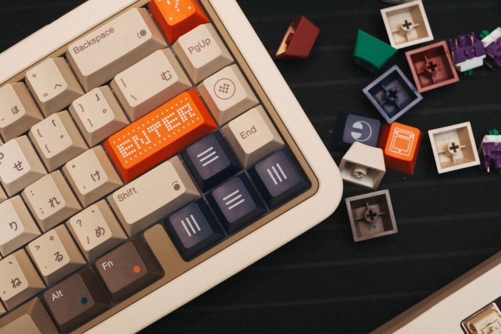 Loose colorful keycaps lying next to a beige mechanical keyboard