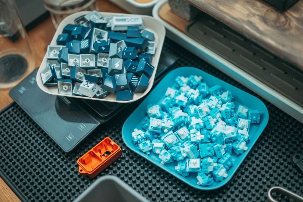 Mechanical keyboard switches and keycaps sorted into trays during a deep clean